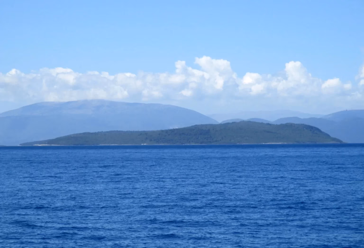 Aerial view of Arkoudi island surrounded by the blue waters of the Inner Ionian Archipelago.